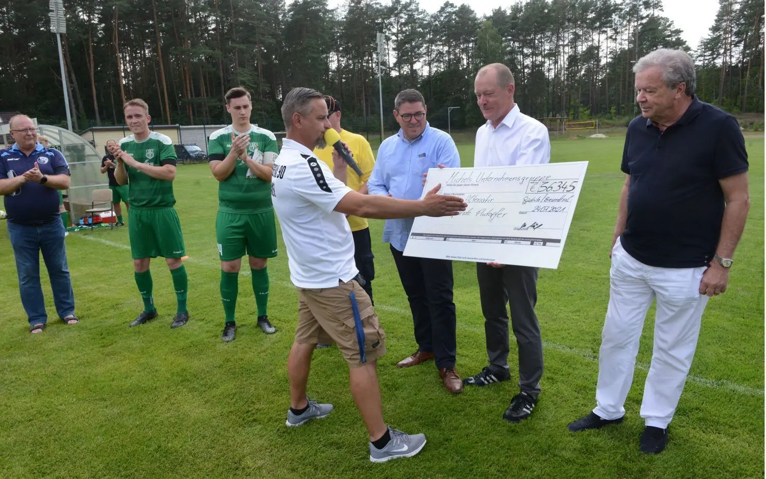 Kai-Uwe Michels (im weißen Hemd mit dem Scheck) von der Michels Gruppe brachte eine Spende über mehr als 56.000 Euro auf den Sportplatz nach Biesenthal.