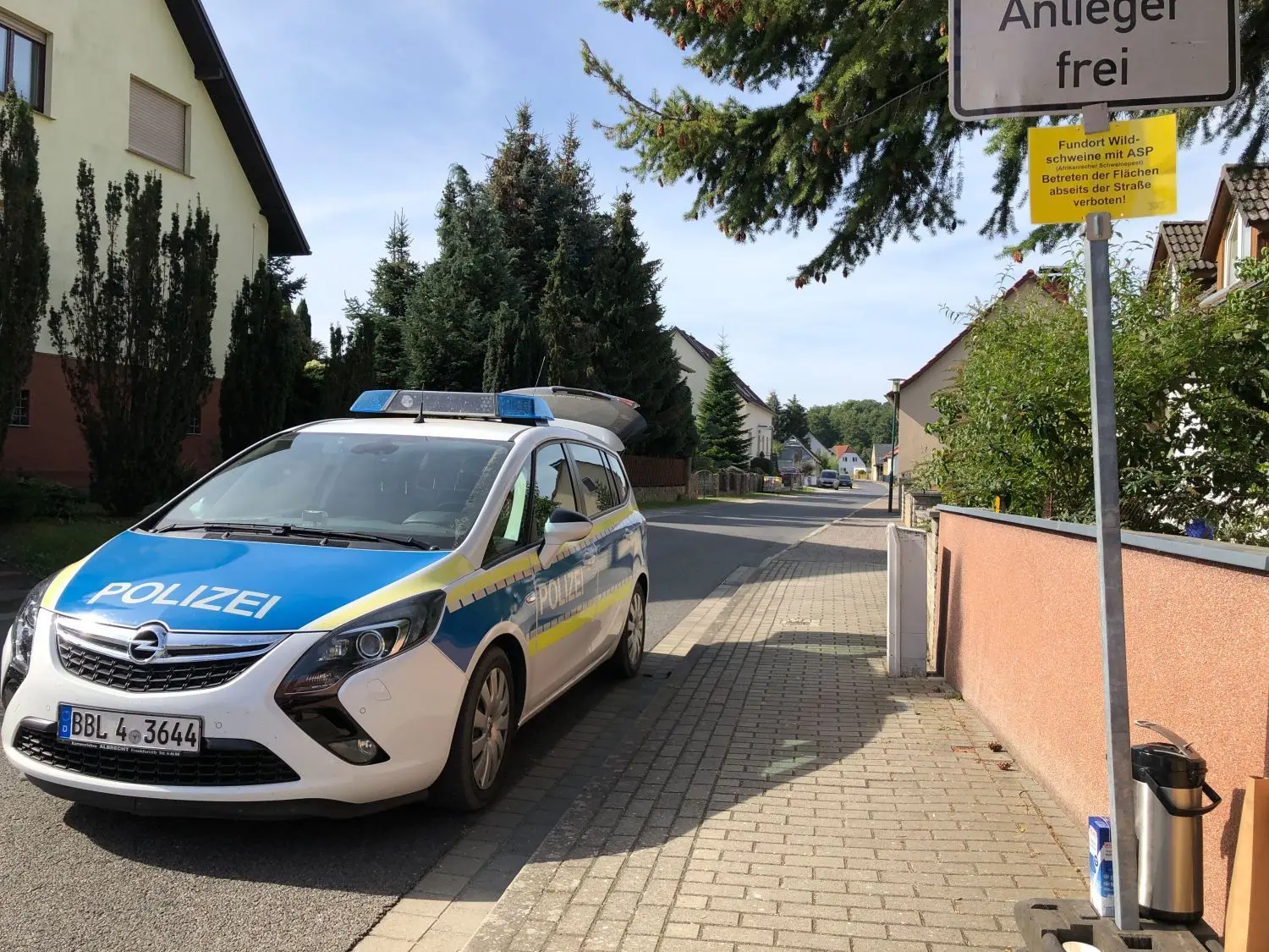 Zur Sicherheit: Die Polizei sperrt eine Straße in der Schweinepest-Kernzone Neuzelle für die Suchaktion ab.