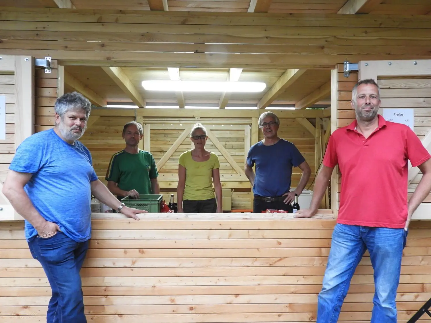 Eine neue Treppe für das Schwimmerbecken, ein Pavillon für den Bademeister und ein Mehrzweckraum (siehe Foto) wurden in dieser Saison errichtet. Ortsvorsteher Bodo Sternberg (li.), Michael Golze (re.) und die Mitglieder des Freibadvereins im Hintergrund sind stolz darauf.