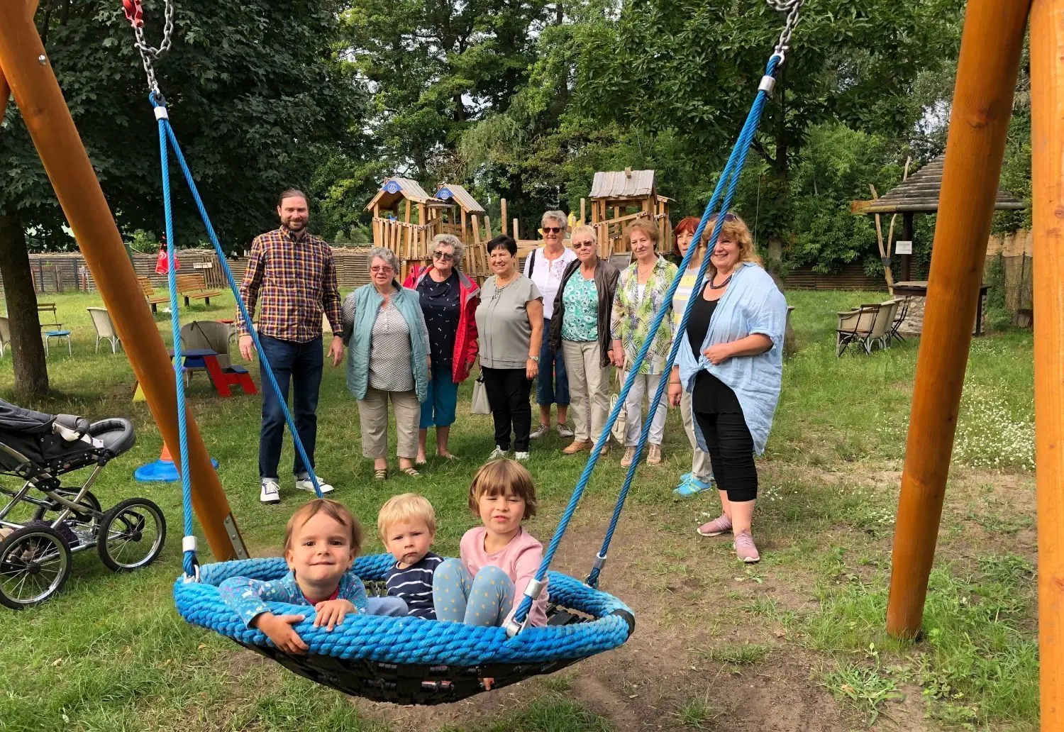 Die ersten Nutzer: Sinja (2,5), Jona (1,5) und Frieda (4, v.l.) aus Berlin-Friedrichshagen lassen sich von Margret Huth in der neuen Nestschaukel im Kinderbauernhof Mümmelmann anschubsen. Sie wurde vom Kinderhilfeverein in Petershagen-Eggersdorf spendiert. Sieben Frauen waren bei der Premiere dabei und freuten sich, das das Gerät ankommt.