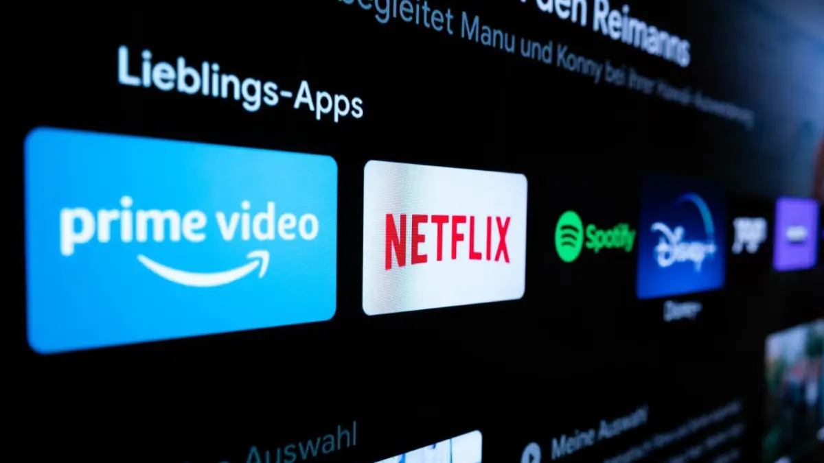 Netflix gibt es bald günstiger, dafür führt der Streamingriese Werbung in einem neuen Abo-Modell ein.
ARCHIV - 07.03.2022, Baden-Württemberg, Rottweil: Auf einem Fernseher in einer Wohnung sind verschiedene Streaming-Dienste (Amazon Prime Video (l-r), Netflix, Spotify, Disney+) zu sehen. Am 29.08.2022 feiert der Streaming-Anbieter seinen 25. Geburtstag. (zu dpa: «25 Jahre Netflix: Der Streaming-König schwächelt») Foto: Silas Stein/dpa +++ dpa-Bildfunk +++