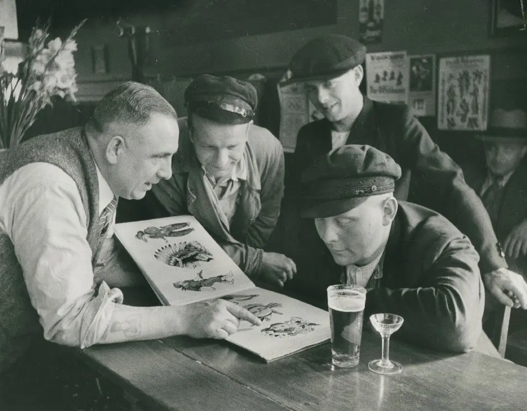 Entscheidung beim Bier: Christian Warlich zeigt Kunden sein Vorlagealbum, aufgenommen um 1936