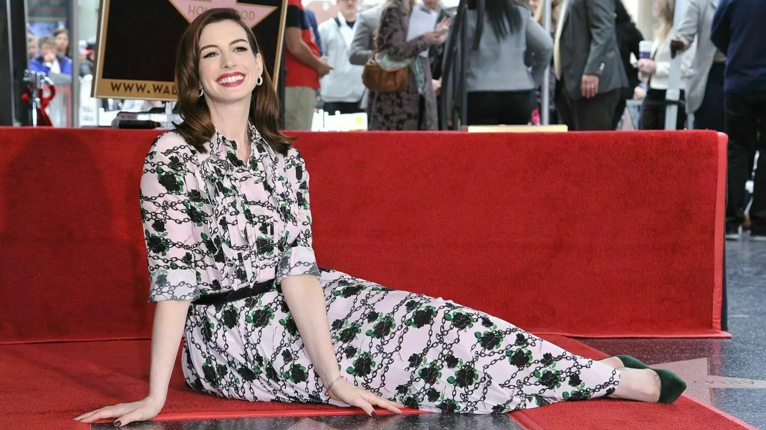 Die Schauspielerin Anne Hathaway sitzt hinter ihrem Stern auf dem Hollywood Walk of Fame.