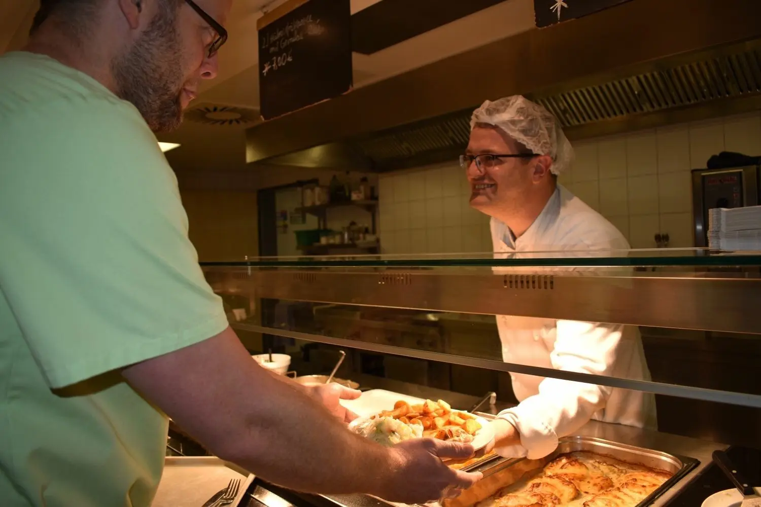 Rund 200 Essen werden täglich im Klinikum gekocht. Weitere 200 Portionen werden den Patienten über einen Tielkühlservice der Asklepios-Gruppe zur Verfügung gestellt. An der Essenausgabe der Kantine gibt Koch Thomas Horn ein Mittagessen an einen Mitarbeiter aus.