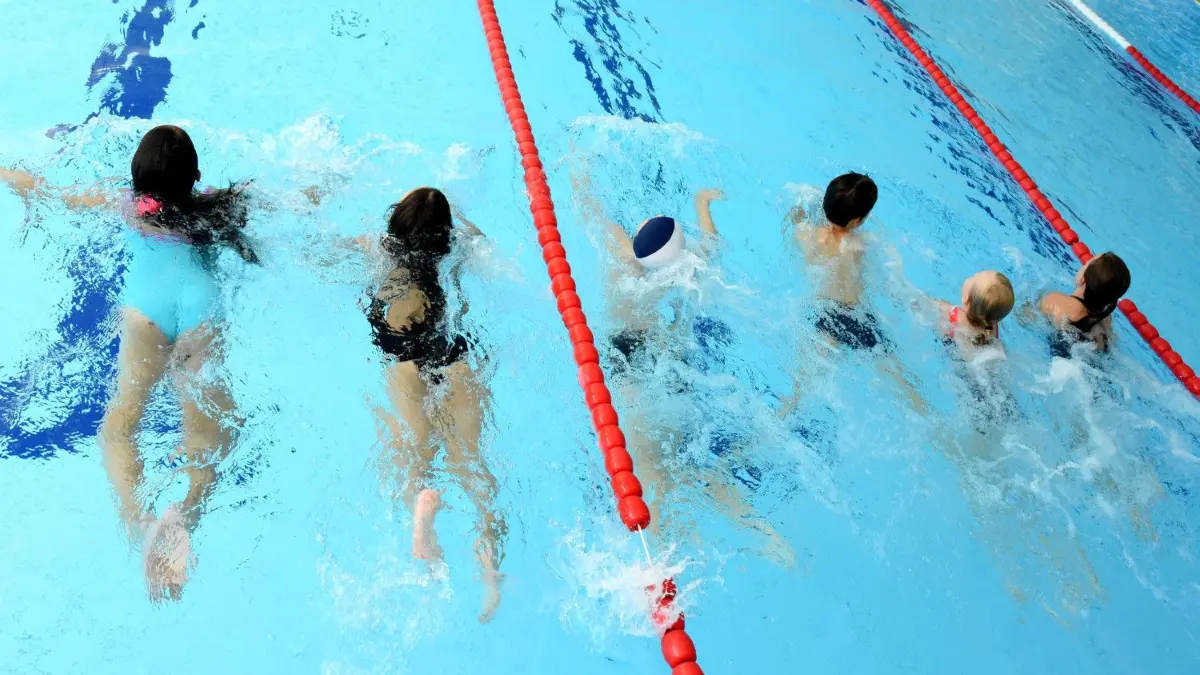 In der Schwimmhalle Süd in Leipzig nehmen Schüler während der Ferien am zusätzlich angebotenen Schwimmunterricht teil. Zu den Angeboten von Vereinen und Sportbädern hatte das Land Sachsen auch Gutscheine für Kinder ausgegeben.
31.07.2021, Sachsen, Leipzig: In der Schwimmhalle Süd nehmen Schülerinnen und Schüler während der Ferien am zusätzlich angebotenen Schwimmunterricht teil. Da wegen Corona in den letzten Monaten der obligatorische Schwimmunterricht ausfallen musste, geben sie jetzt in der extra geöffneten Schwimmhalle den Schwimmunterricht für die Kinder. Zu den Angeboten von Vereinen und Sportbädern hatte das Land Sachsen auch Gutscheine für Kinder ausgegeben, die im Schuljahr 2019/20 das Schwimmen nicht erlernt hatten. Foto: Waltraud Grubitzsch/dpa-Zentralbild/dpa - ACHTUNG: Nur zur redaktionellen Verwendung im Zusammenhang mit der aktuellen Berichterstattung zum Thema "Sächsische Schüler holen verpassten Schwimmunterricht nach" +++ dpa-Bildfunk +++