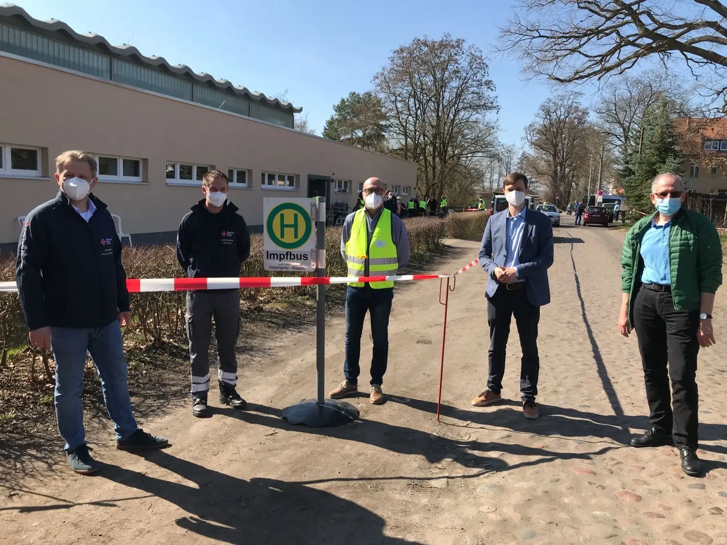 Ronny Sattelmair und Daniel Franz (beide DRK), Thomas Fengler von der Stadt Neuruppin, Bürgermeister Nico Ruhle sowie Vize-Landrat Werner Nüse (von links) freuen sich über den Erfolg des Corona-Impfbusses.