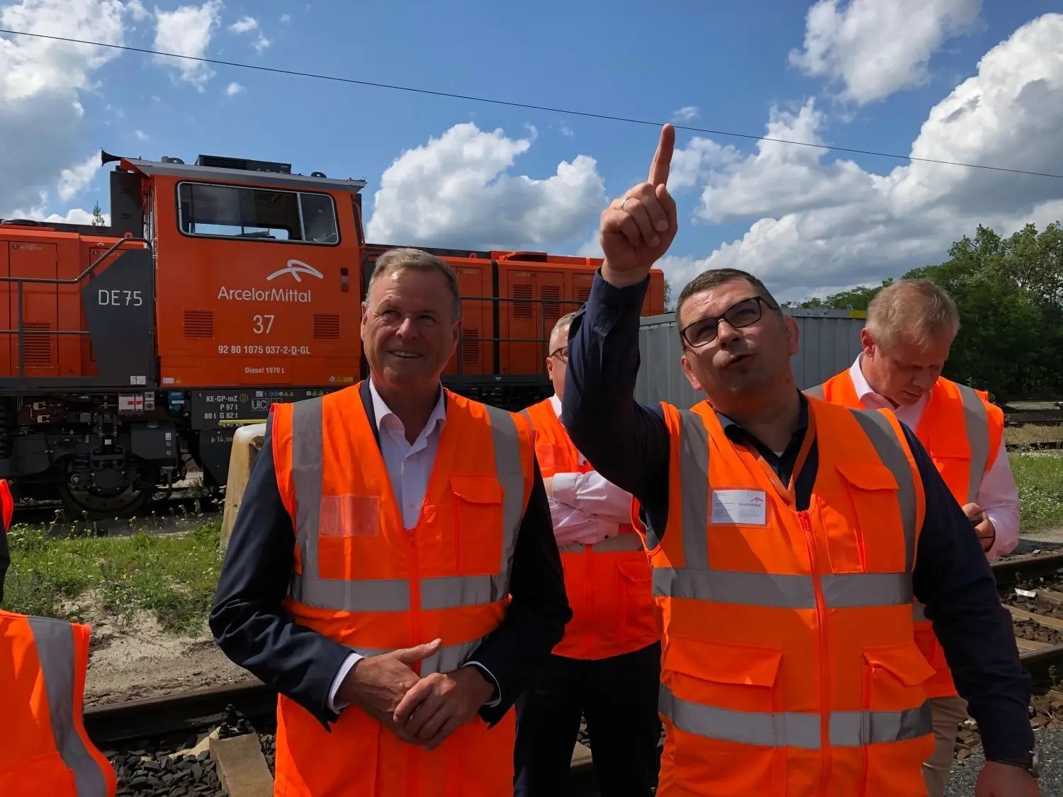 Auf dem Werkbahnof von ArcelorMittal Eisenhüttenstadt: Besuch von Christian Görke (l.), Mitglied des Bundestages und Sprecher für Finanzpolitik der Linksfraktion im Bundestag, hier mit Stefan Nemack, Geschäftsführer bei ArcelorMittal Eisenhüttenstadt Transport GmbH. Hinter den Männern steht eine neu angeschaffte, moderne Lok.Ausbau des Werkbahnhofs geplant