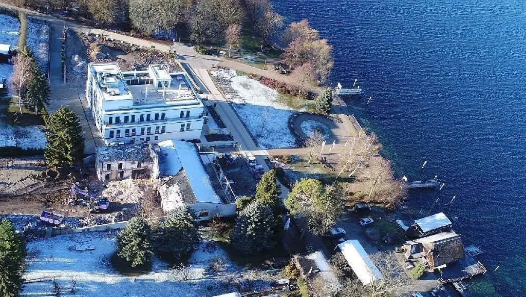 Großbaustelle Altenhof: Rings um das weiß strahlende Fontane-Hotel wird derzeit kräftig gebaut. Während die ehemalige HO-Gaststätte hinter dem Hotel bereits weg ist, wird vorn am ehemaligen „Strandpavillon“ noch gebaggert. Hier soll ein Wellness-Bereich des Hotels entstehen. Im oberen Teil des Bildes, auf der Fläche der ehemaligen „Seeterrasse“, werden derzeit Bäume gerodet.