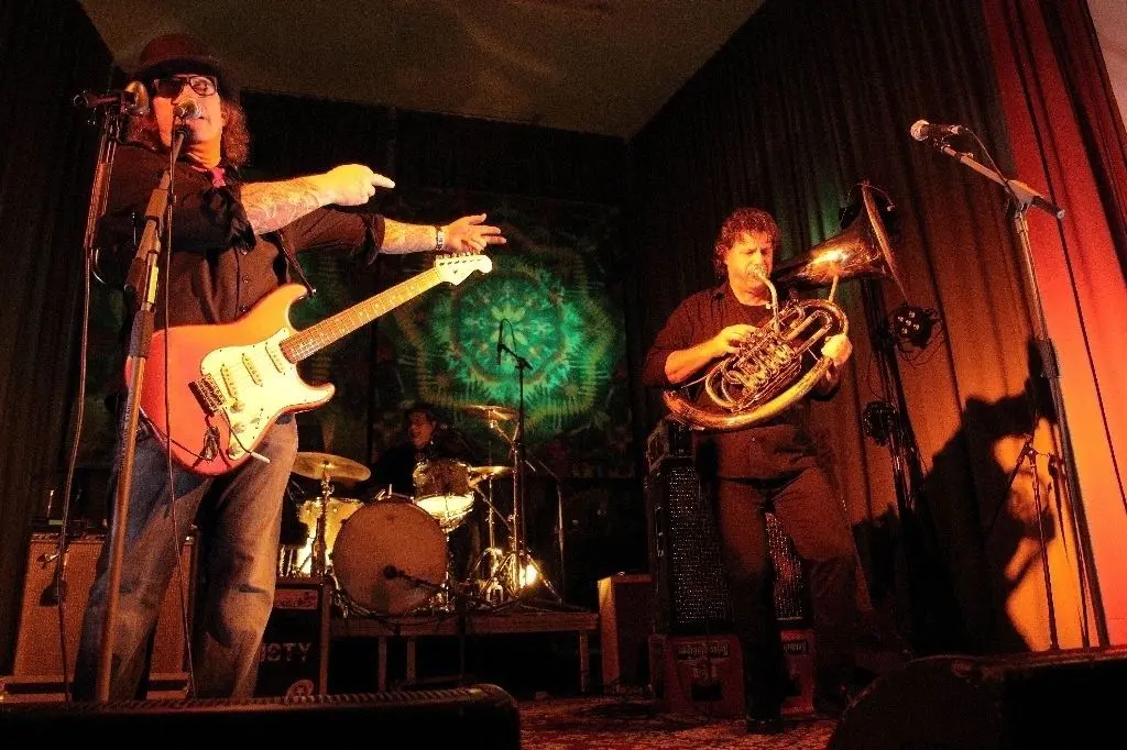Live In Reitwein im Lebuser Kulturhaus: Bei der 120. Veranstaltung des gleichnamigen Vereins rockte am Samstagabend die Münchener Band "Reverend Rusty & The Case" sogar mit Tuba. Sänger Reverend Rusty Stone (l.) spielte zwischenzeitlich auch direkt in den Zuschauerrängen.