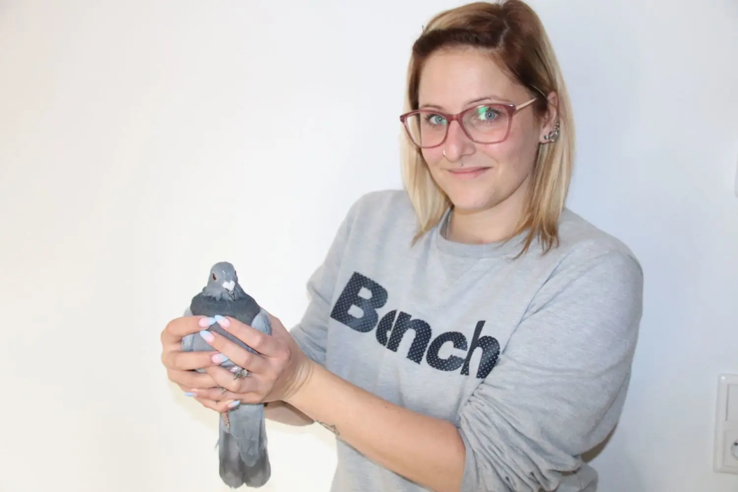Kommt aus Warschau: eine polnische Brieftaube, die Büro-Assistentin Cora Schulenburg in der Hand hält. Das etwa 700 Gramm schwere Exemplar ist im Tierheim an der Vogelsänger Chaussee in Eisenhüttenstadt aufgepäppelt worden.