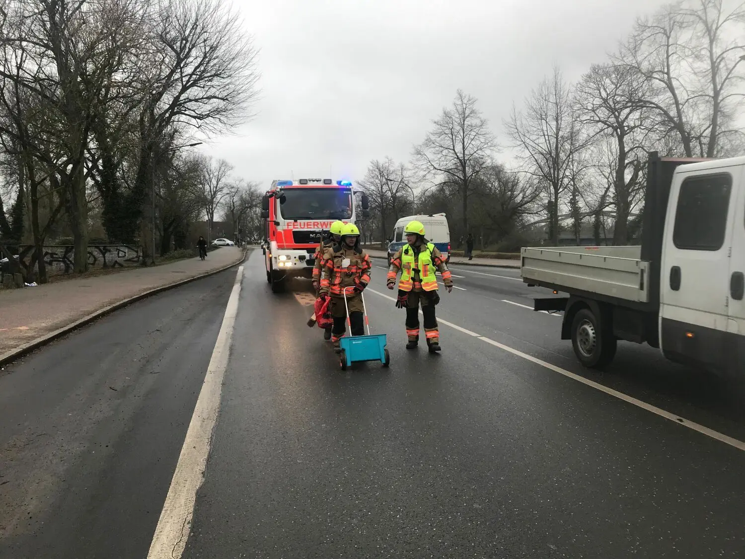 Feuerwehrleute aus Fürstenwalde beim Beseitigen einer Ölspur in der Bebelstraße.