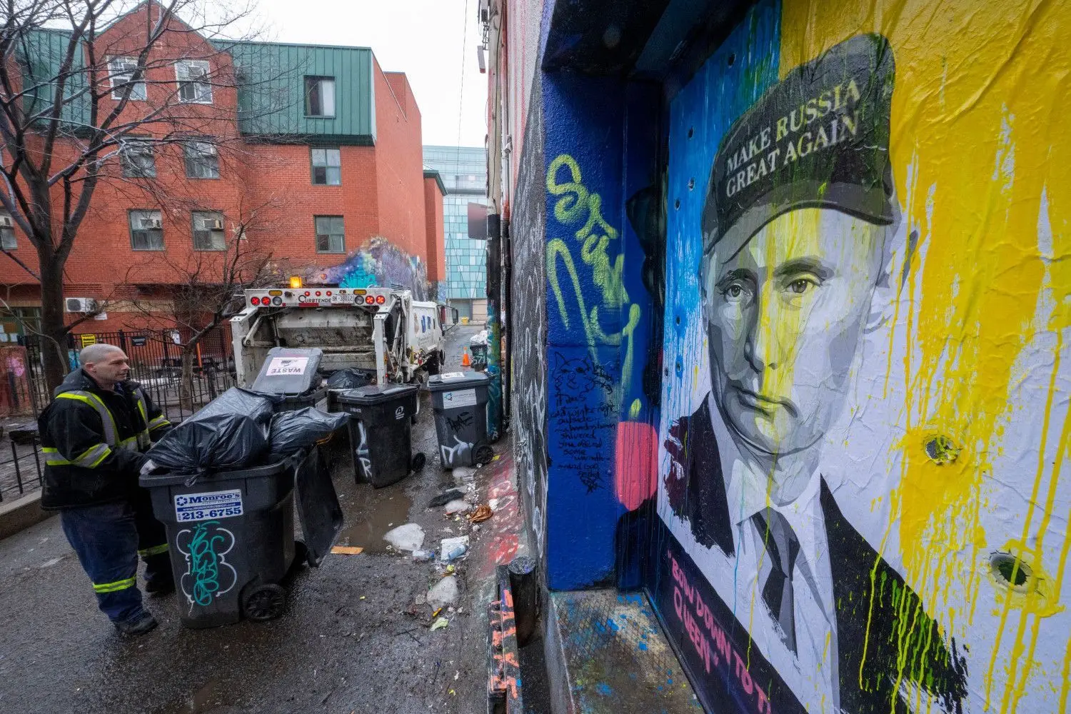Ein Bild aus Kanada: Ein Sanitärtechniker lädt Müll neben einem in ukrainischen Farben gemalten Plakat des russischen Präsidenten Putin. „Make Russia great again“ steht auf der Mütze. Was will der Präsident von Russland mit dem Krieg erreichen?