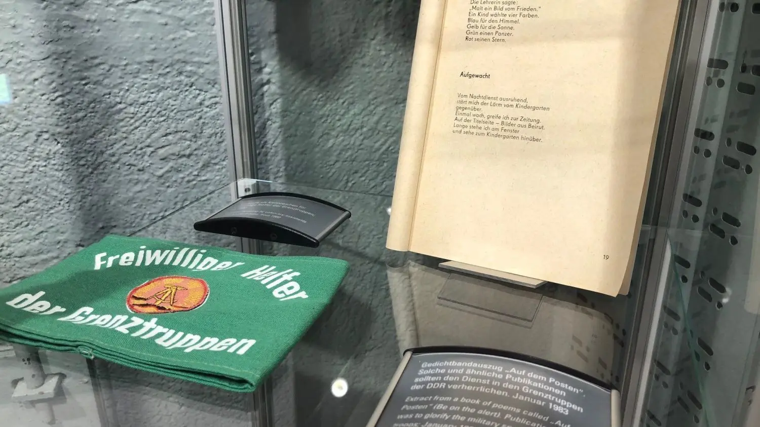 Heute eher peinlich: ein Band mit Gedichten, die Grenzsoldaten motivieren sollten, und die Binde eines freiwilligen Helfers der DDR-Grenztruppen.