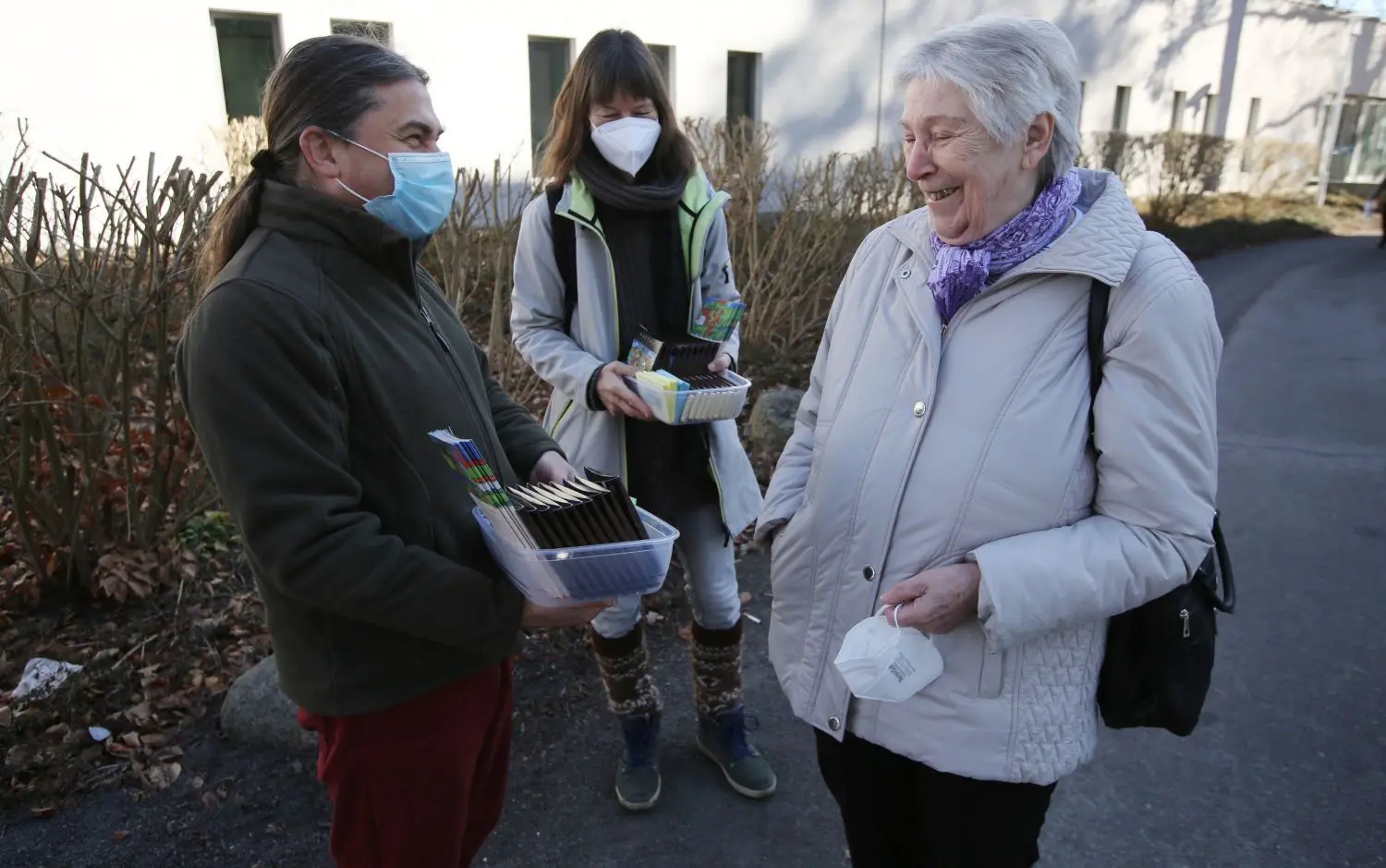 Nette Geste vor dem Impfzentrum: Torsten Pelikan und Claudia Ibisch von der Fairtrade-Initiative verschenken eine Tafel der Stadtschokolade „fairnaschen“ an Christel Rehtfeld aus Eberswalde.