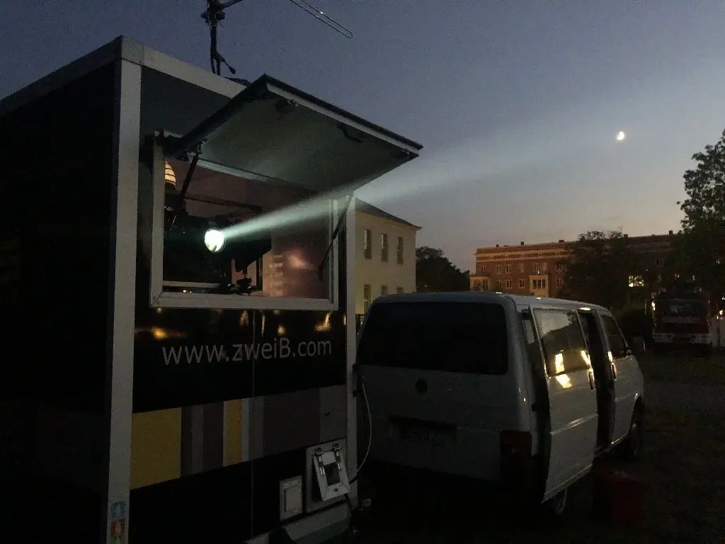 Ein strahlender Anblick: Der Lichtkegel des Projektor ist schon aus der Ferne zu sehen. Nachdem es dunkel wird, ist das Bild auf der Leinwand in satten Farben zu sehen.