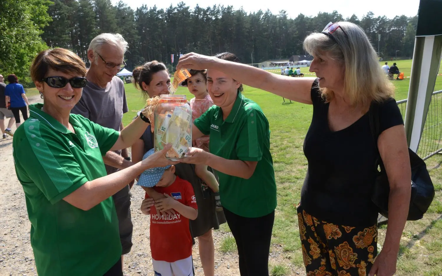 Mehrere Tausend Euro spendeten die Zuschauer des Benefizspiels am Eingang des Sportplatzes. Ute Puhlmann (rechts) legte 50 Euro in die Spendendose. Sie war mit Ehemann, "Wuschel" Puhlmann, ihrer Tochter Marie-Elisa Puhlmann sowie den Enkeln Rémy und Eleanor gekommen. Janine Rost (links) und Mandy (links neben Ute Puhlmann) nahmen die Spenden am Eingang entgegen.
