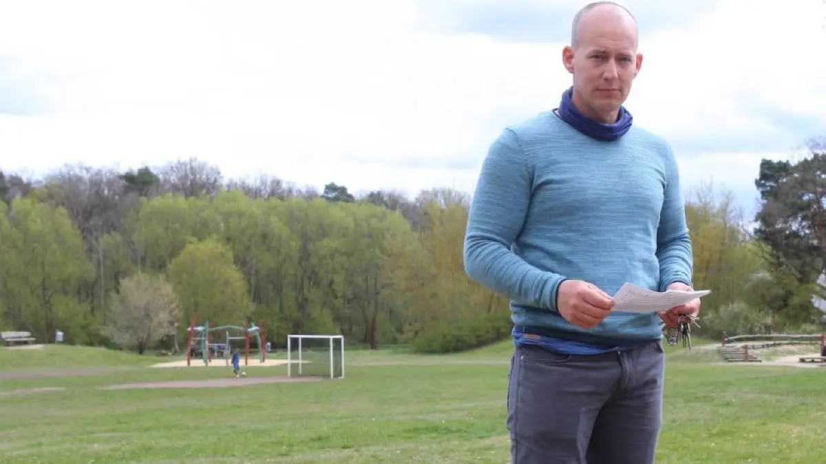 Christian Arndt bei den Stumpen der Bäume am Bolzplatz in Birkenstein. Hinter ihm spielen Kinder.
27.4.2021 Christian Arndt bei den Stumpen der Bäume am Bolzplatz in Birkenstein
