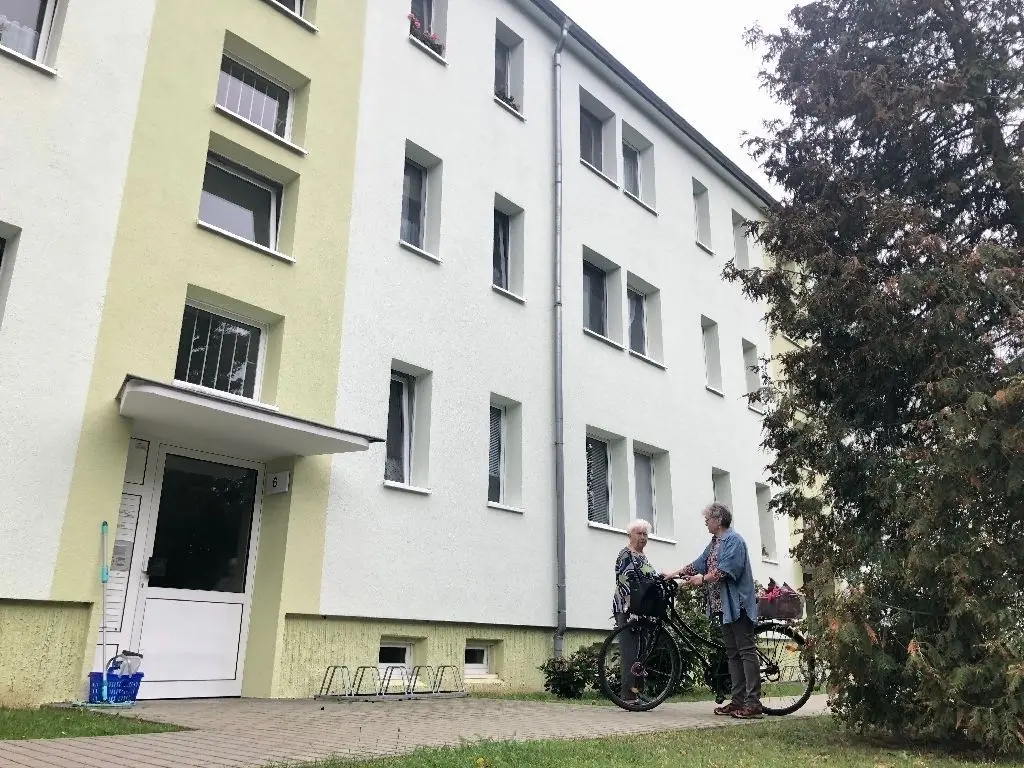 Entwickelt sich weiter: Die Wohnungsbaugesellschaft Werneuchen will neben diesem bestehenden Mietblock neu bauen. Stefan Lochner (links) zeigt das anvisierte Baufeld.