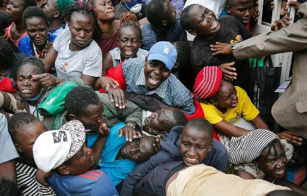 Arme können keinen Abstand halten: In Nairobi (Kenia) drängen Bewohner durch ein Tor zu einer  geplanten Verteilung von Nahrungsmitteln.