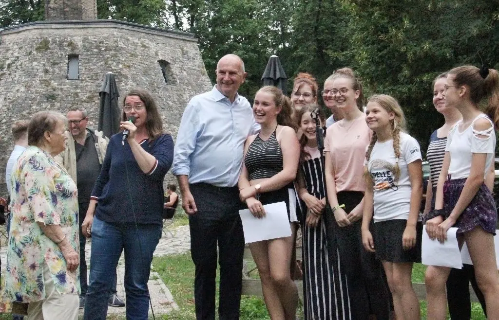 Erklärungen: SPD-Direktkandidatin Elske Hildebrandt (mit Mikrofon) stellt Brandenburgs Ministerpräsident Dietmar Woidke im Museumspark die Pelle Kids (r.) und Seniorin Renate Radoy (l.) vor. Die übergibt kurz darauf ein verziertes Straußenei an Woidke.