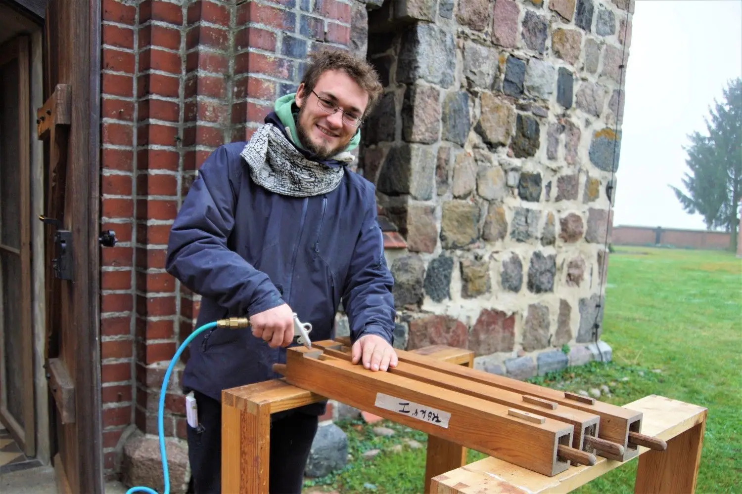 Conrad Blechschmidt, der bei der Orgelbaufirma Scheffler eine Ausbildung macht, reinigt die Holzpfeifen in Gottberg mit Druckluft.