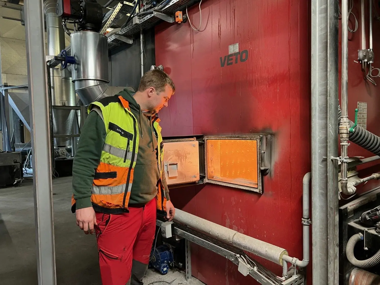 Baumpfleger Timo Bittner schaut in den Ofen des Heizkraftwerks in Fürstenwalde.