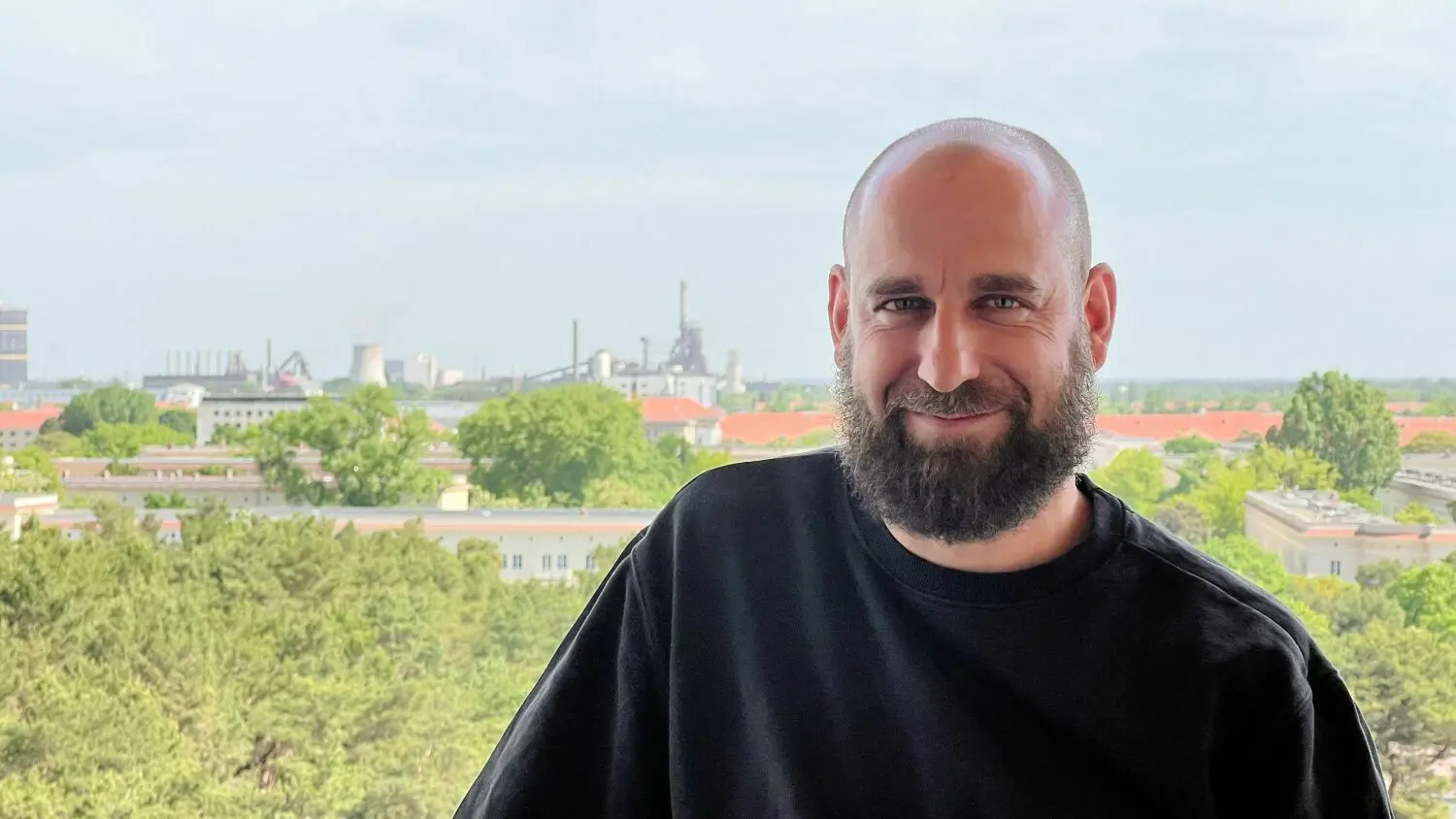 Martin Maleschka auf seinem neuen Balkon in Eisenhüttenstadt. Der Architekt ist umgezogen, ganz in die Nähe vom Platz der Jugend, auf den Anfang Juni Tausende Augen gerichtet sein werden, wenn dort die zentrale Eröffnung von Kulturland Brandenburg stattfindet.