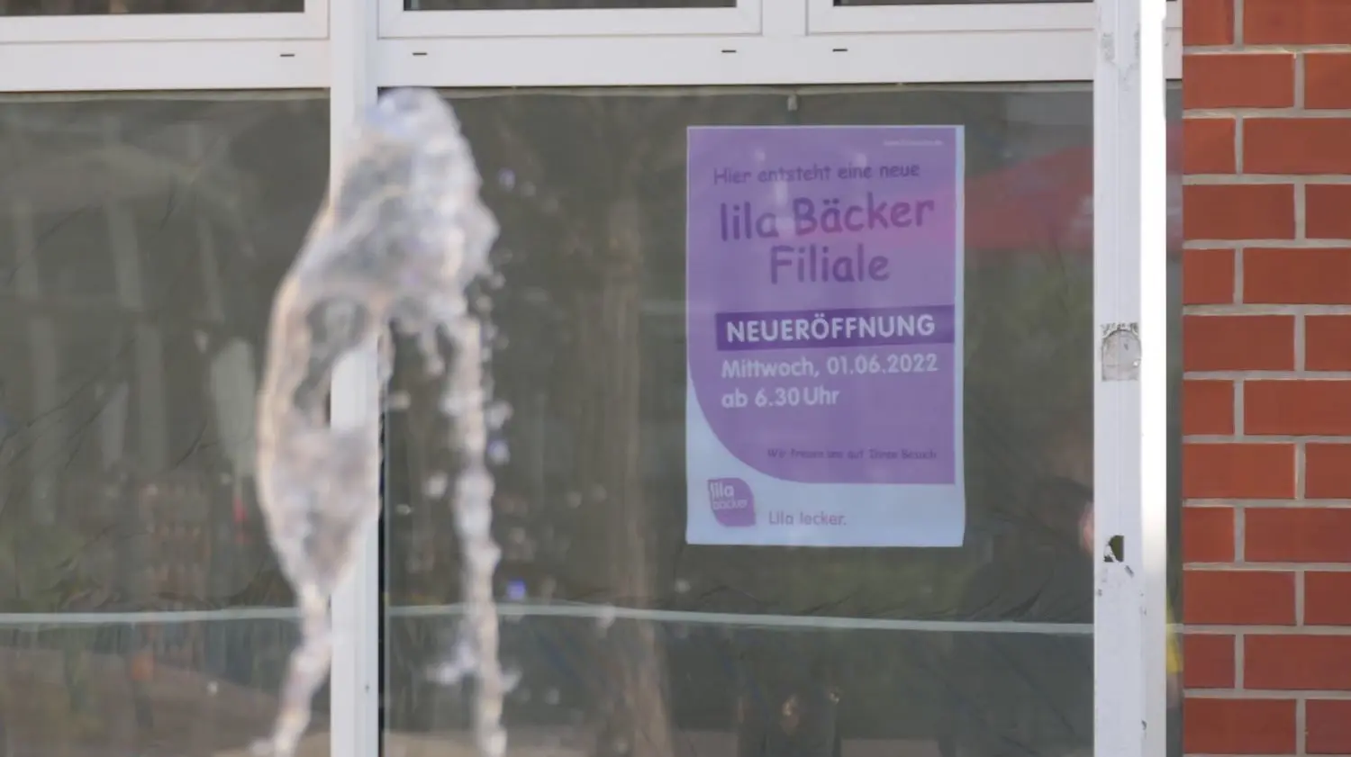 Von der Farbe des Plakats lässt sich bereits auf den neuen Ladeninhaber schließen: Die Kette Lila Bäcker eröffnet eine Filiale am Markt von Velten.