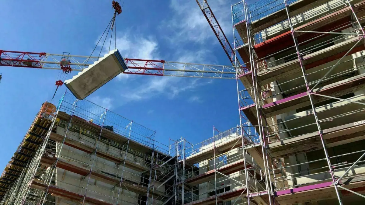 Ein Treppenelement schwebt über dem Neubau, den die WGH an der Schrodaer Straße in Hennigsdorf bauen lässt. Der Rohbau ist bereits so gut wie fertig.
WGH Neubau Schrodaer Straße Hennigsdorf René Sperber Bauleiter Matthias Kunz (rechts) März 2023