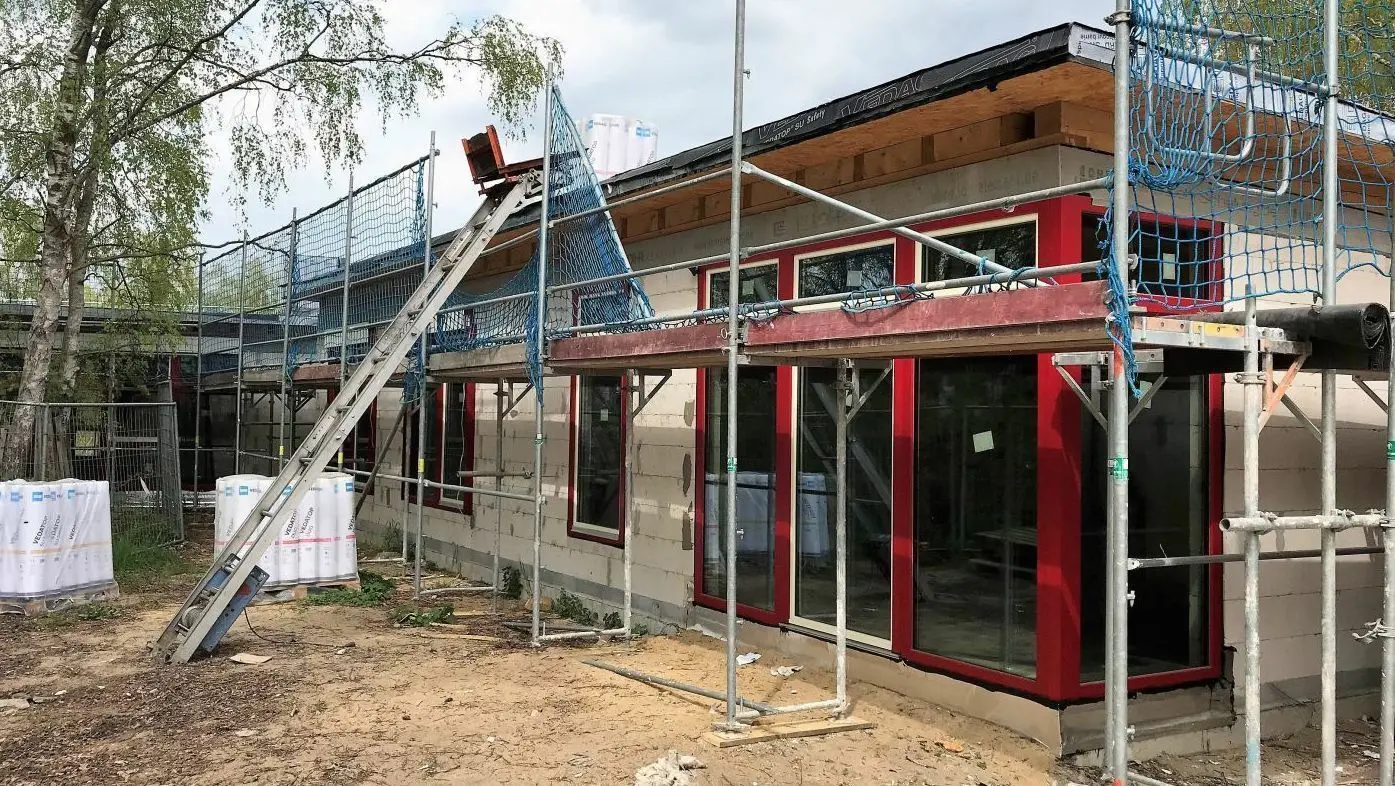 Es geht langsam voran: Der Rohbau des evangelischen Kindergartens steht seit Ende 2021. Nach Lieferschwierigkeiten haben nun die Arbeiten für die Dämmung des Daches begonnen. Wann wird er eröffnet?