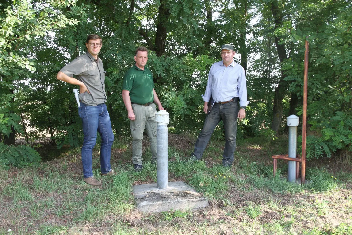 An der Messstelle des Landesumweltamtes - rechts für Grundwasser, links für Belastungen: Fabian Blöchl, Refereatsleiter Landesbauernverband, Frank Prochnow vom Öko-Landhof Jahnsfelde und Landesbauernverbands-Präsident Henrik Wendorff, der mit seiner AGW in Worin ebenfalls ökologischen Landbau betreibt.