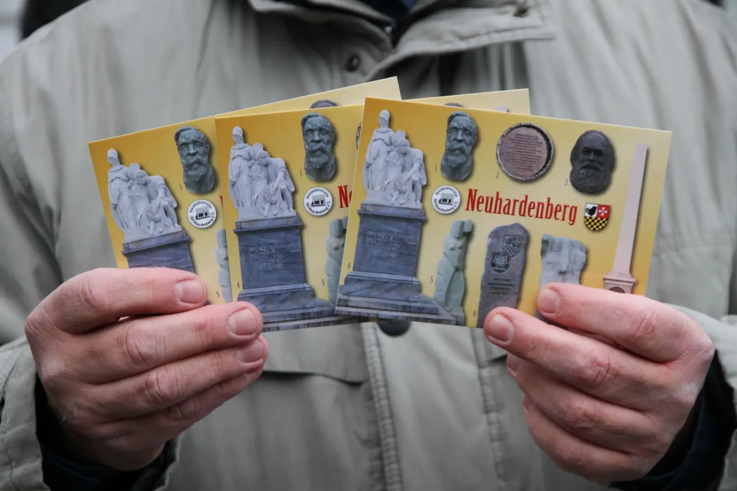 Feierlich: Heimatvereinschef-Dietmar Zimmermann präsentierte bei der Geschichtspfad-Enthüllung an der Neuhardenberger Grundschule zum 200. Geburtstag von Friedrich Engels (28.11.) auch neue Postkarten mit Ansichten verschiedener Denkmäler in Neuhardenberg.