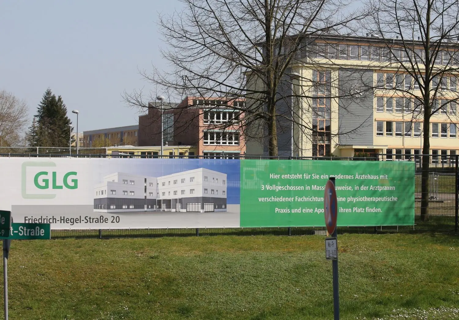 So soll das neue Ärztehaus aussehen: Ein Banner zeigt den Entwurf. Geplant ist ein dreigeschossiger Baukörper in L-Form.