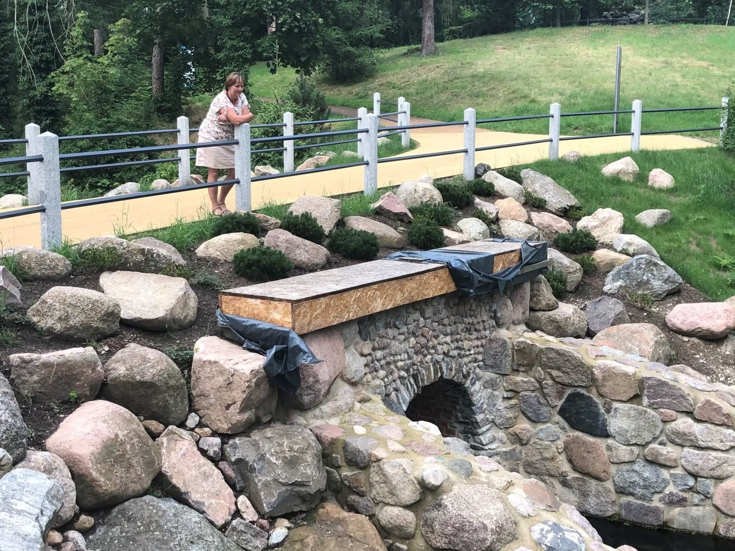 Bergwelt-Feeling: Die Leiterin des Grünflächenamtes Dorit Bunk schaut von der neuen Brücke auf die Grotte und den Wasserlauf herunter.