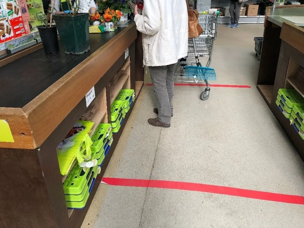 Mit roten Klebestreifen weist der Pflanzenmarkt Kölle vor den Kassen auf den Sicherheitsabstand hin.