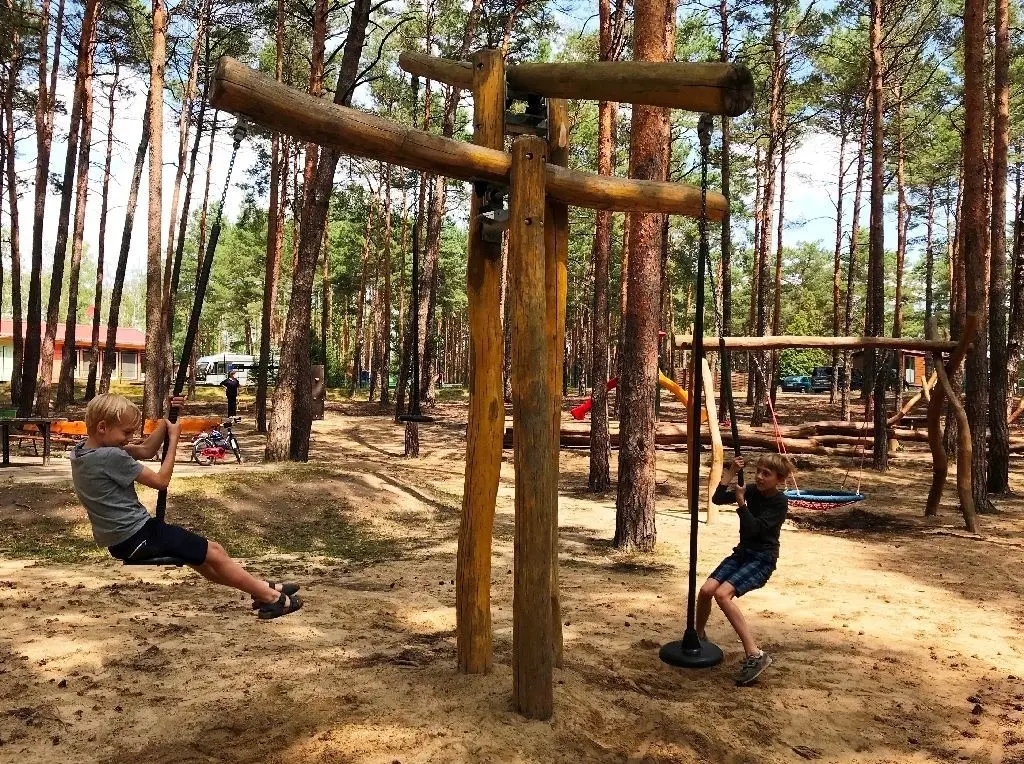 Oscar und Victor schaukeln auf dem großen Abenteuerspielplatz.