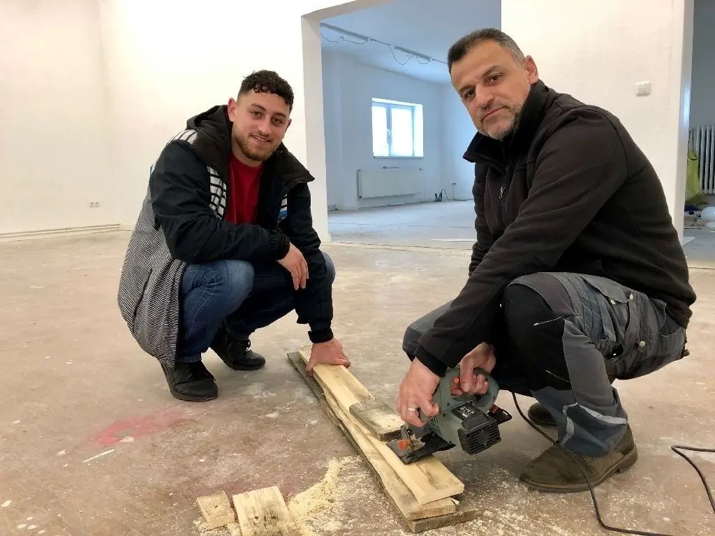 Richten den Gebetsraum gemeinsam mit anderen Freiwilligen her: Izzeldeen Hayajneh (rechts) mietet die Immobilie im Julius-Pintsch-Ring. Mit seinem Sohn Obieda sägt er Holzleisten für den Innenausbau zurecht.