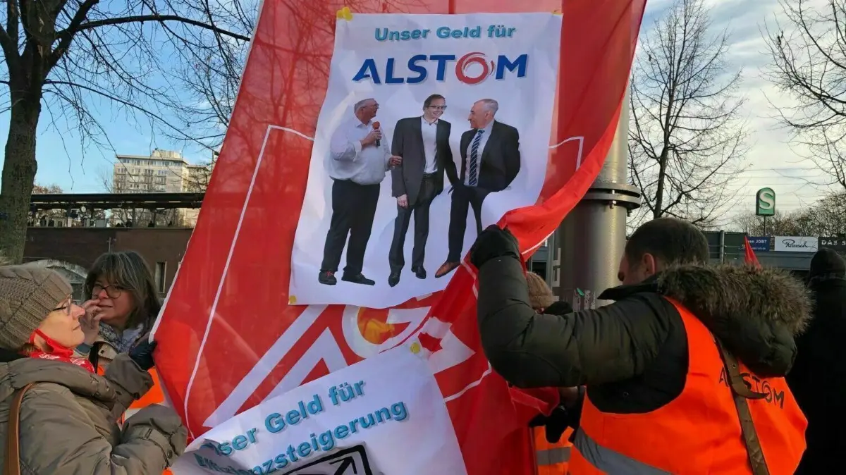 Manchmal bleibt nur noch Ironie: Mitte Dezember protestierten Alstom-Beschäftigte aus ganz Deutschland dagegen, dass ihnen nicht nur Jobs, sondern auch Geld genommen werden sollen.
Alstom Protest vor Novotel Berlin Tiergarten Hennigsdorf Demonstranten von allen deutschen Standorten vor Ort auch MdB Ariane Fäscher 14. Dezember 2022