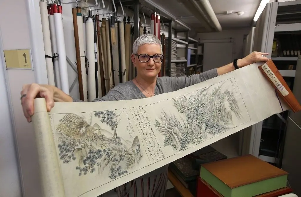 Japanische Schriftrolle: Einer der Schätze der Eberswalder Hochschulbibliothek ist das handbeschriebene Lehrbuch, das Leiterin Claudia Adler hier aufrollt. Es zeigt Szenen aus dem forstwirtschaftlichen Arbeitsleben im Japan des 19. Jahrhunderts.