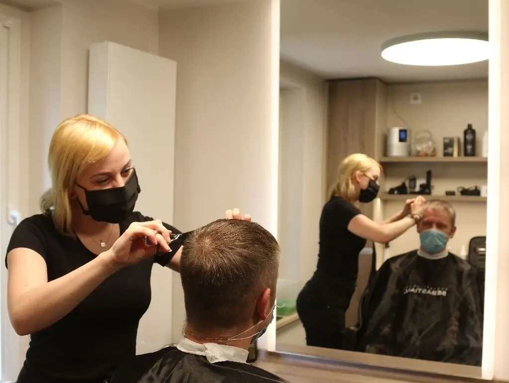 Mit Mundschutz im Mund-Nasen-Schutz arbeitet Linda Dewitz im Salon Schwefel in Neutrebbin und schneidet einem Kunden, ebenfalls mit Schutz, die Haare. Den ganzen Tag mit Maske zu arbeiten, bezeichneten mehrere Friseurinnen als unangenehm.