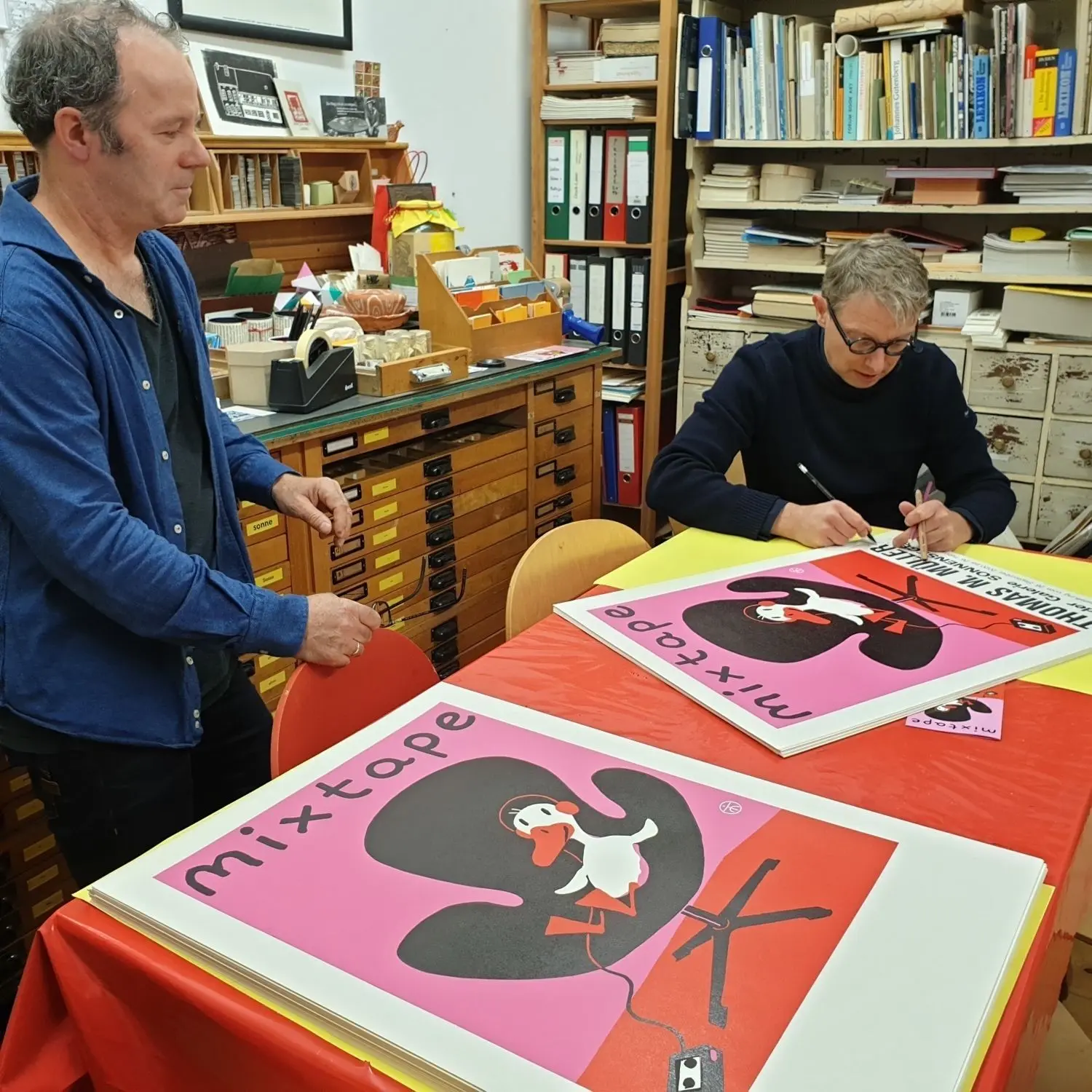 Zur Ausstellungseröffnung signierte Thomas M. Müller Ausstellungsplakate im Sonnensegel-„Druckladen“.