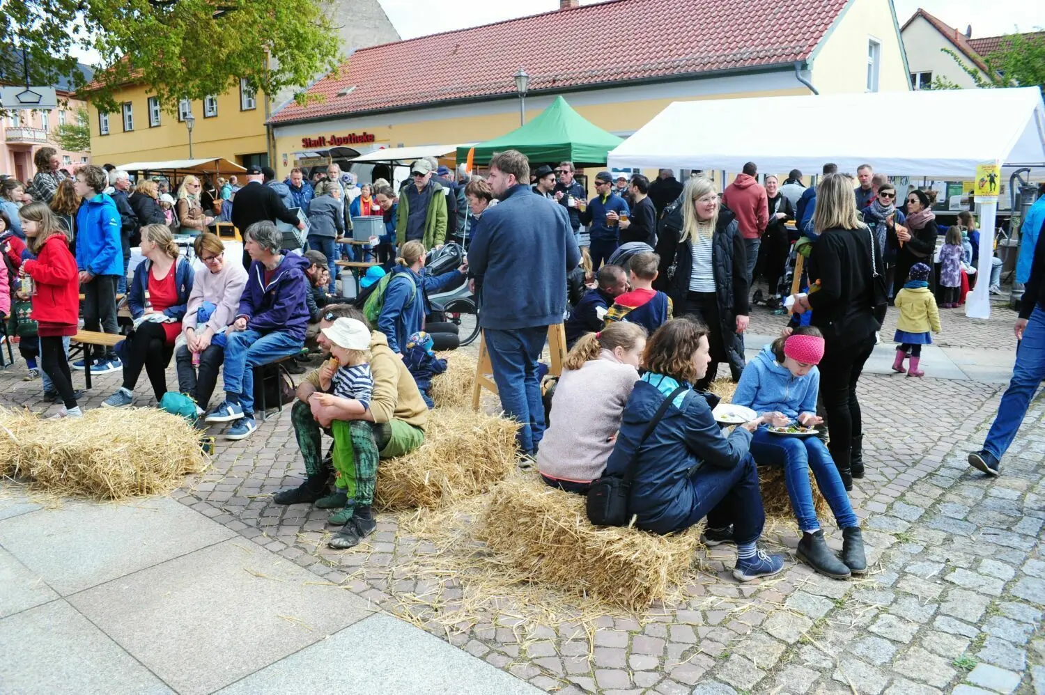Blick über den Marktplatz: Kinder toben und spielen, die Leute essen und reden miteinander.