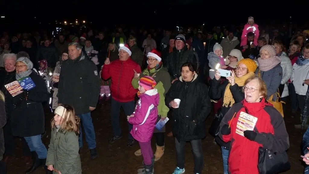 In Stimmung: Jung und alt trällerten die vielen Weihnachtslieder, mancher mit Hilfe des "Liederbuches", das extra für die Premiere am Sonnabend gedruckt worden war.