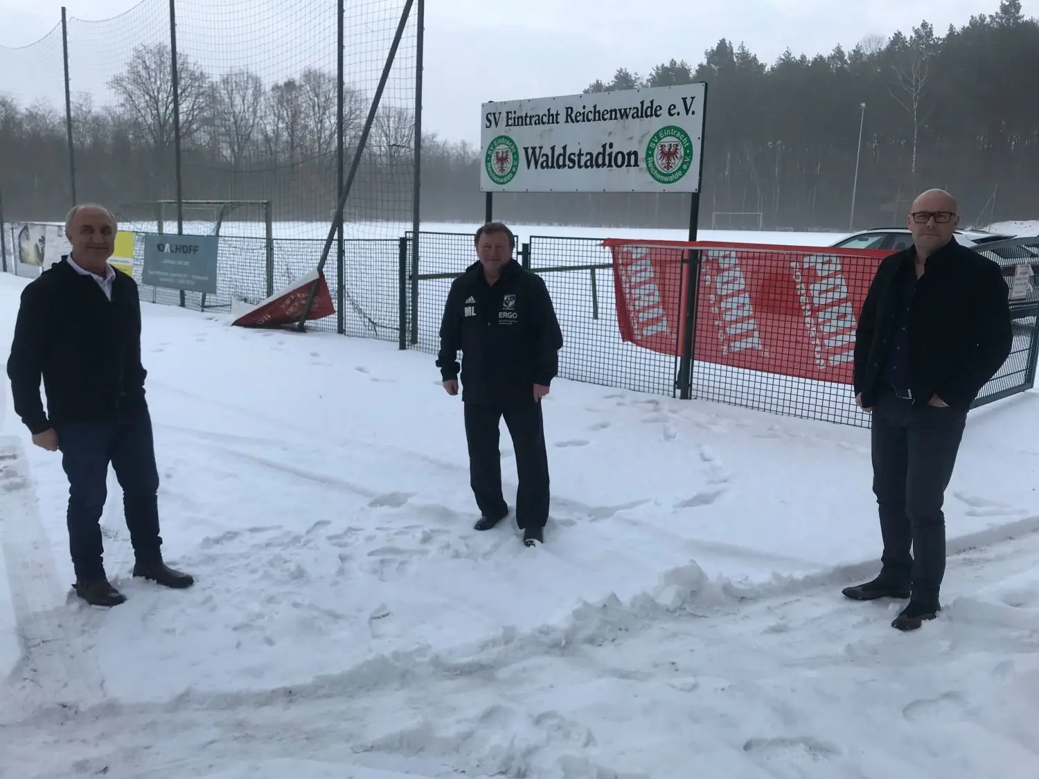 Hier könnte 2024 eine Fußball-Nationalmannschaft trainieren: Das Waldstadion in Reichenwalde. Michael Datschischin, Michael Lampelt und Torsten Reincke (von links) vom Vorstand des SV Eintracht Reichenwalde würden gern Gastgeber sein.