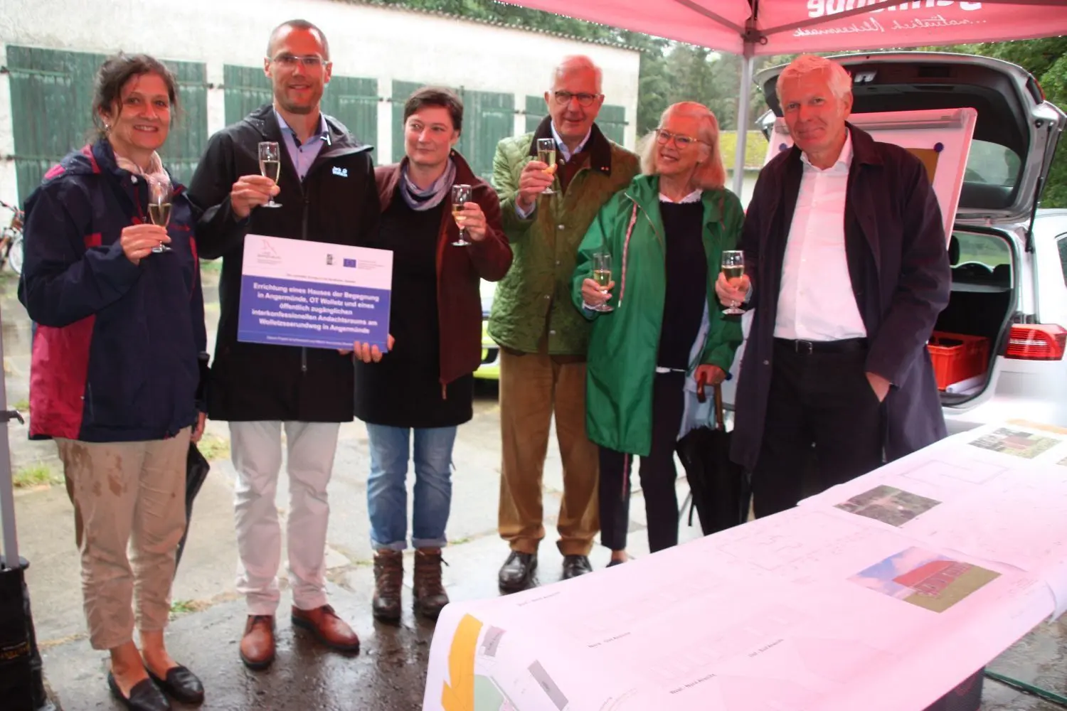 Grundsteinlegung für das Begegnungszentrum in Wolletz: Die Projektpartner stoßen darauf an: Von links: Planerin Elke Hähnel, Bürgermeister Frederik Bewer, Ortsvorsteherin Kristina Wendt, diee Initiatoren Hugo und Lisa Fiege und Architekt Jan Kleihues.