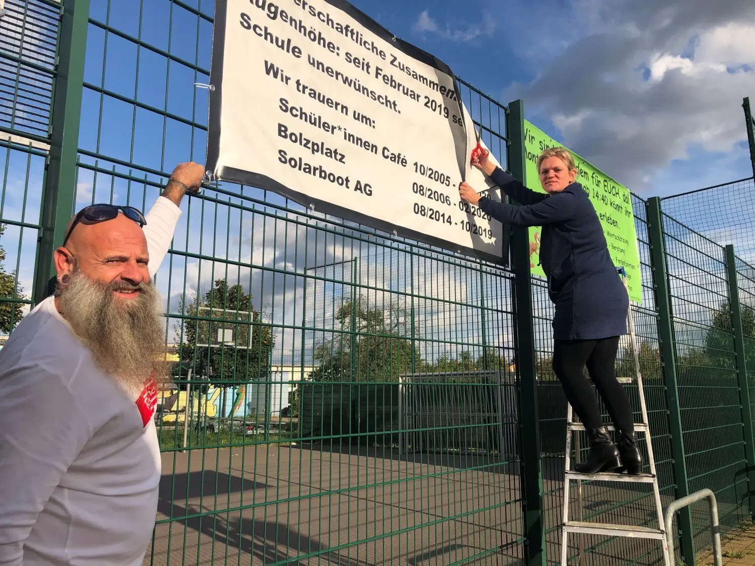 Weg damit! Jugendförderer Jörg Bauer und Direktorin Anja Gehrke-Witthuhn nehmen das Transparent am Bolzplatz in Finowfurt ab, das eine fehlende Zusammenarbeit auf Augenhöhe betrauerte.