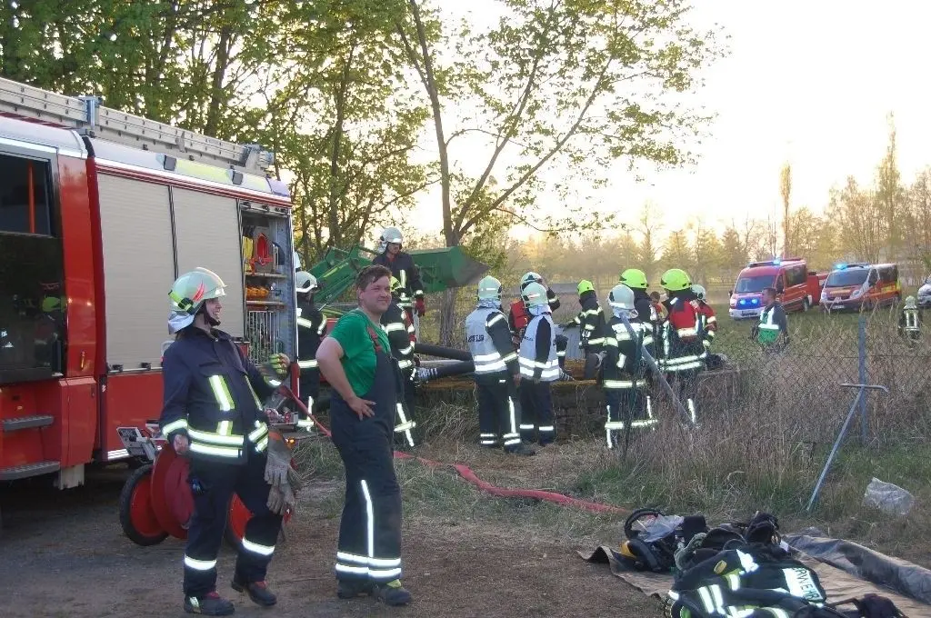 Wasserzufuhr: Feuerwehrleute pumpen Wasser aus Tanklöschfahrzeugen in die Zisterne im Hintergrund.