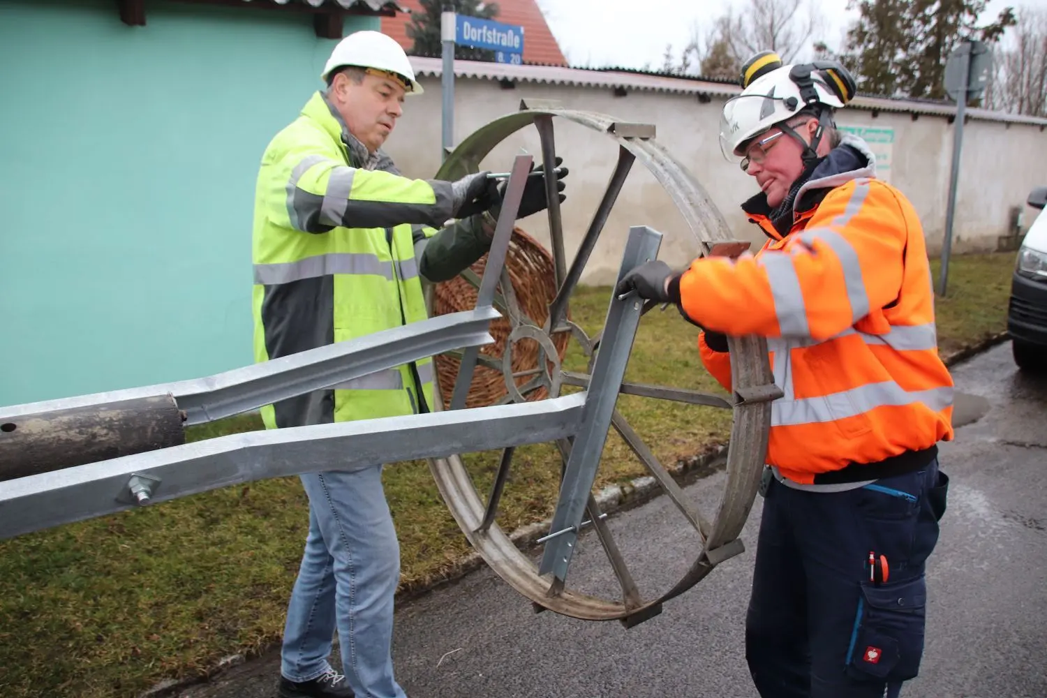 Montieren das Rad der Beregnungsanlage auf den Mast: E.DIS-Netzwerkmeister Uwe Kalisch (links) und Wolfgang Petersen von der Wiesenauer Firma Spie
