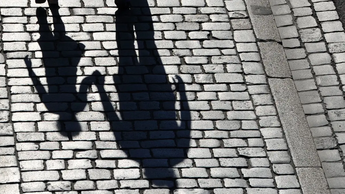 ARCHIV - 24.05.2015, Sachsen, Dresden: Die Schatten einer erwachsenen Person und eines Kindes sind zu sehen. (zu dpa «Aus Angst ums Kind - Jugendämter 2018 häufiger alarmiert») Foto: Matthias Hiekel/ZB/dpa +++ dpa-Bildfunk +++