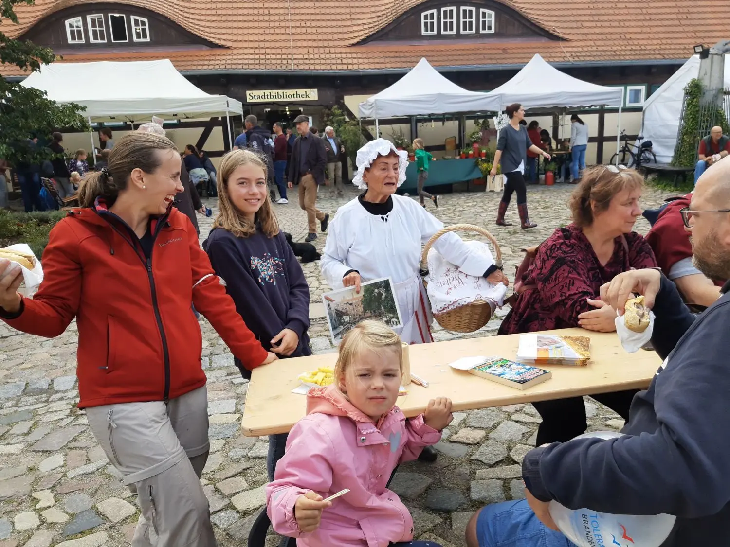 Weitgereiste Besucher: Helga Kühne aus Storkow als Waschfrau Helene am Tisch der Familie Mahnkopf aus München. Rechts Martina Pohl aus Leverkusen.